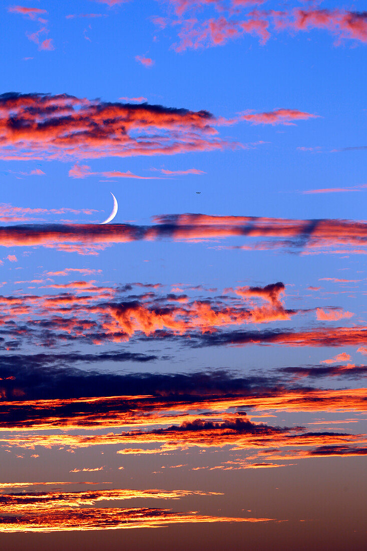 Seine et Marne. Provins. Clouds twilight. Crescent moon emerging from clouds. Airplane.