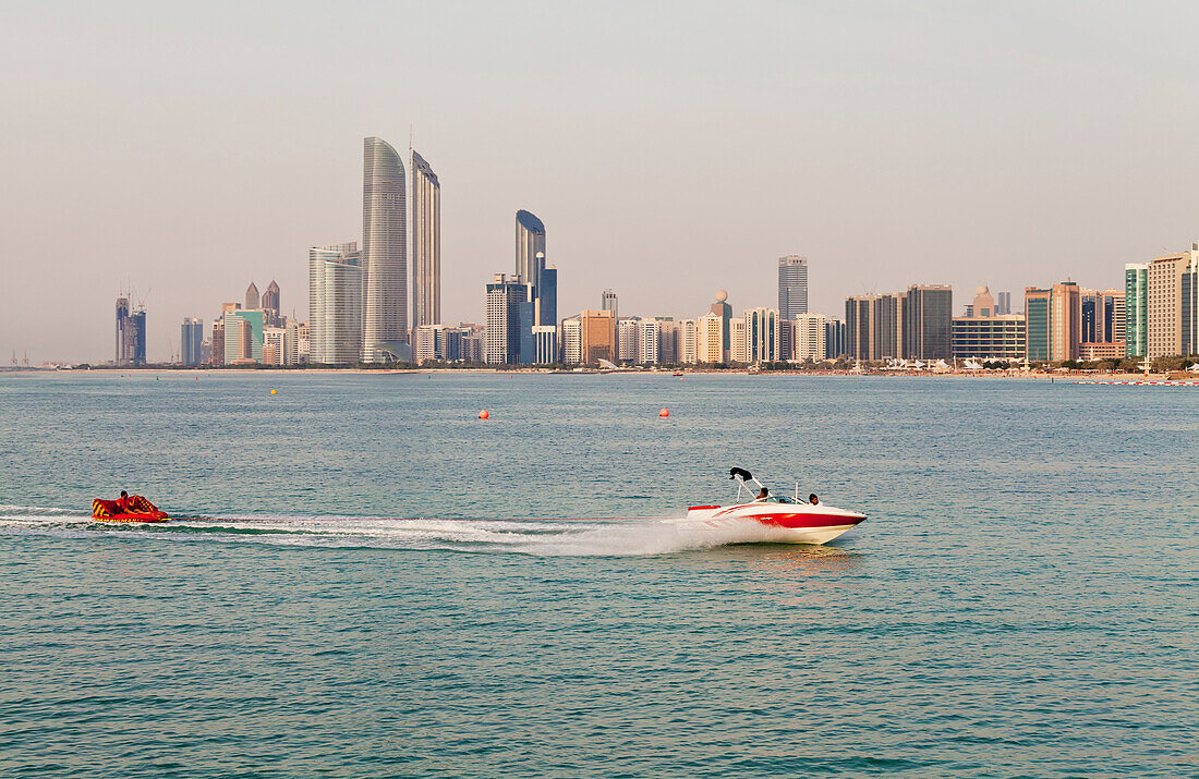 'Jet skiers with the skyline of Abu Dhabi in the background; Abu Dhabi, United Arab Emirates'