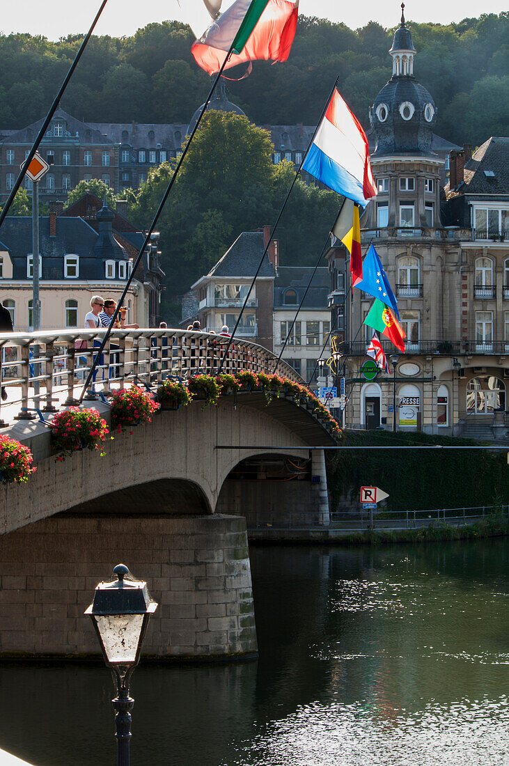 'Bridge with flags crossing the river; Dinant, Ardennes, Belgium'