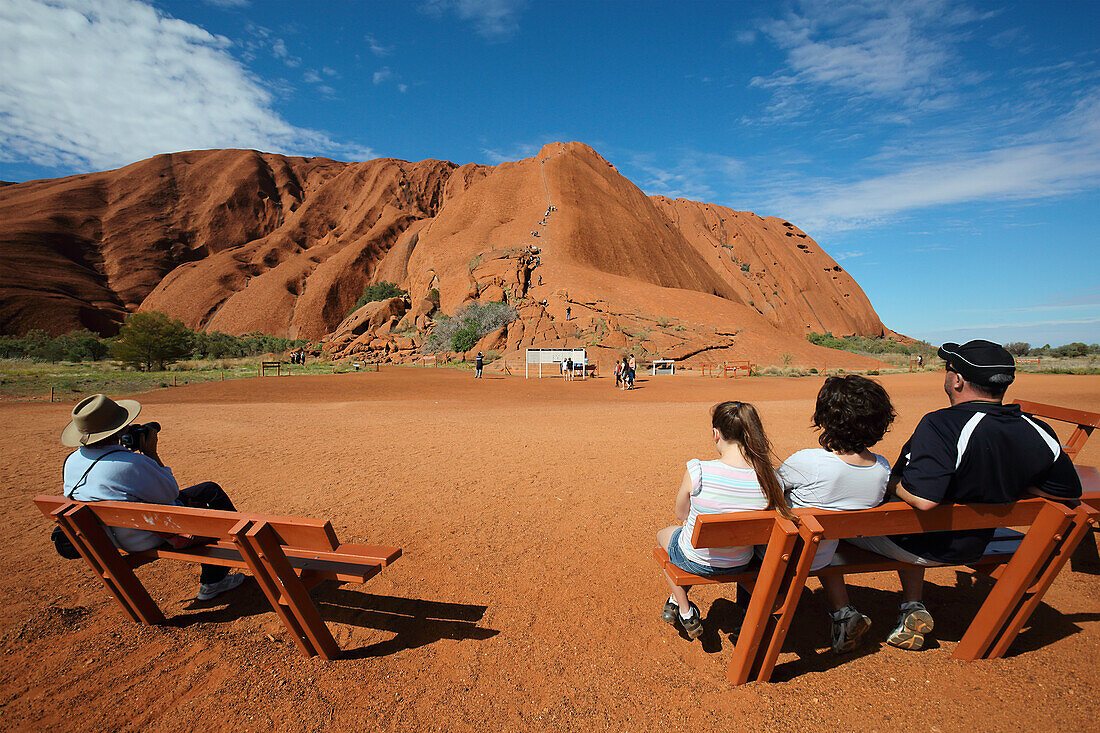 'Tourists watching people climb Uluru, formerly known as Ayers Rock; Northern Territory, Australia'