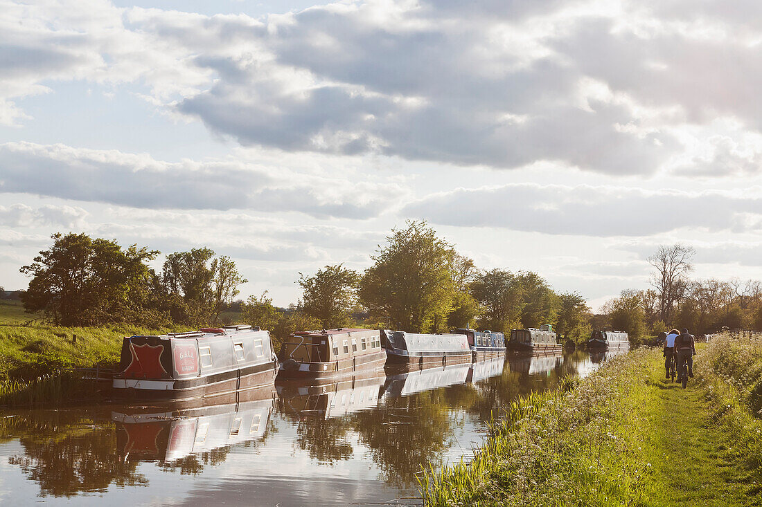 'Cycling along path next to Kennet and Avon Canal; Great Bedwyn, Wiltshire, England'