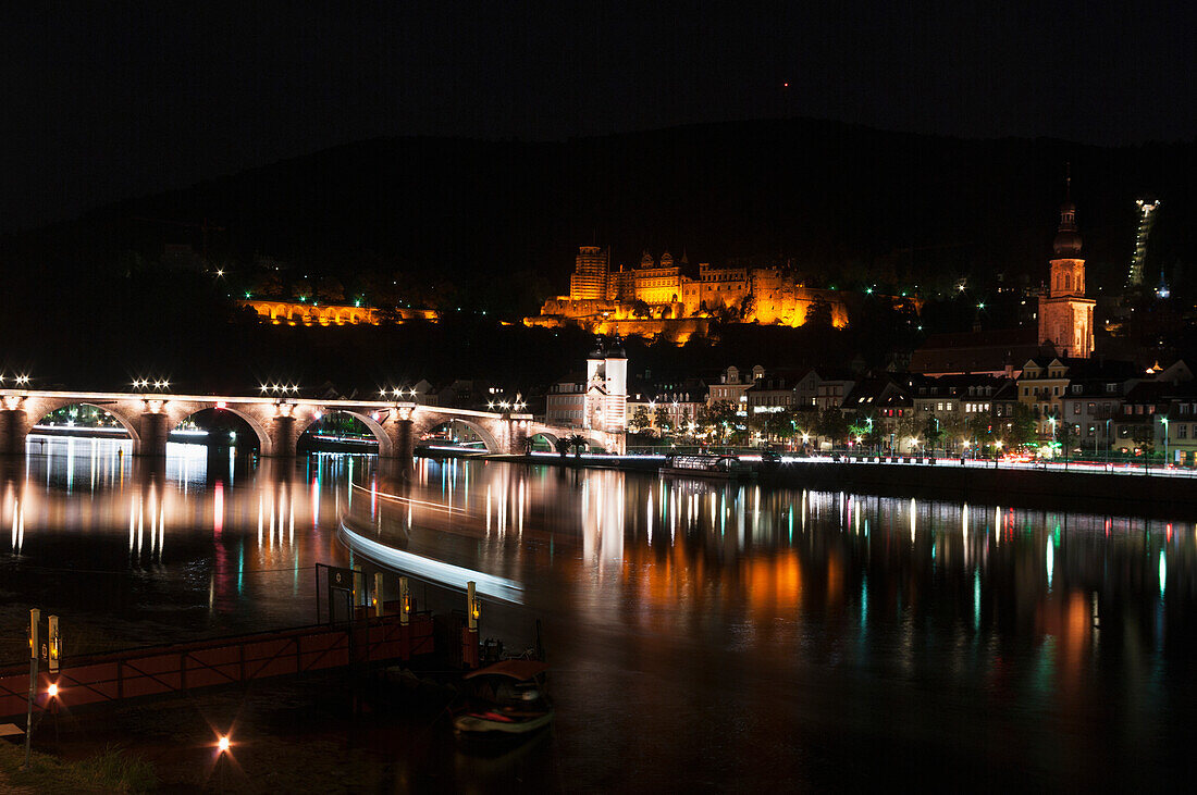 'Heidelberg Castle and the old bridge over River Neckar illuminated at nighttime; Heidelberg, Germany'