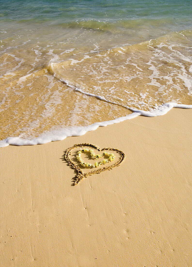 Picture Of A Heart Drawn In The Sand On A Tropical Beach, Yellow Lei Shaped Like A Heart Inside Of Drawing