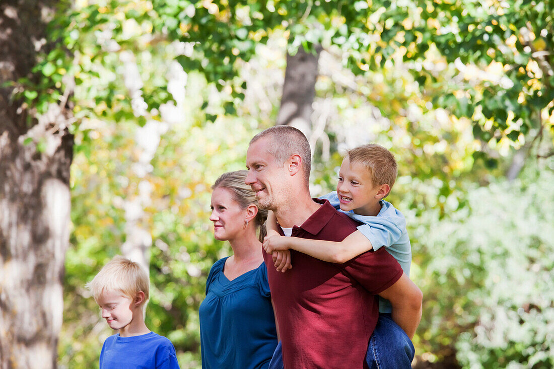 'Family Walking Together In A Park In Autumn; Edmonton, Alberta, Canada'