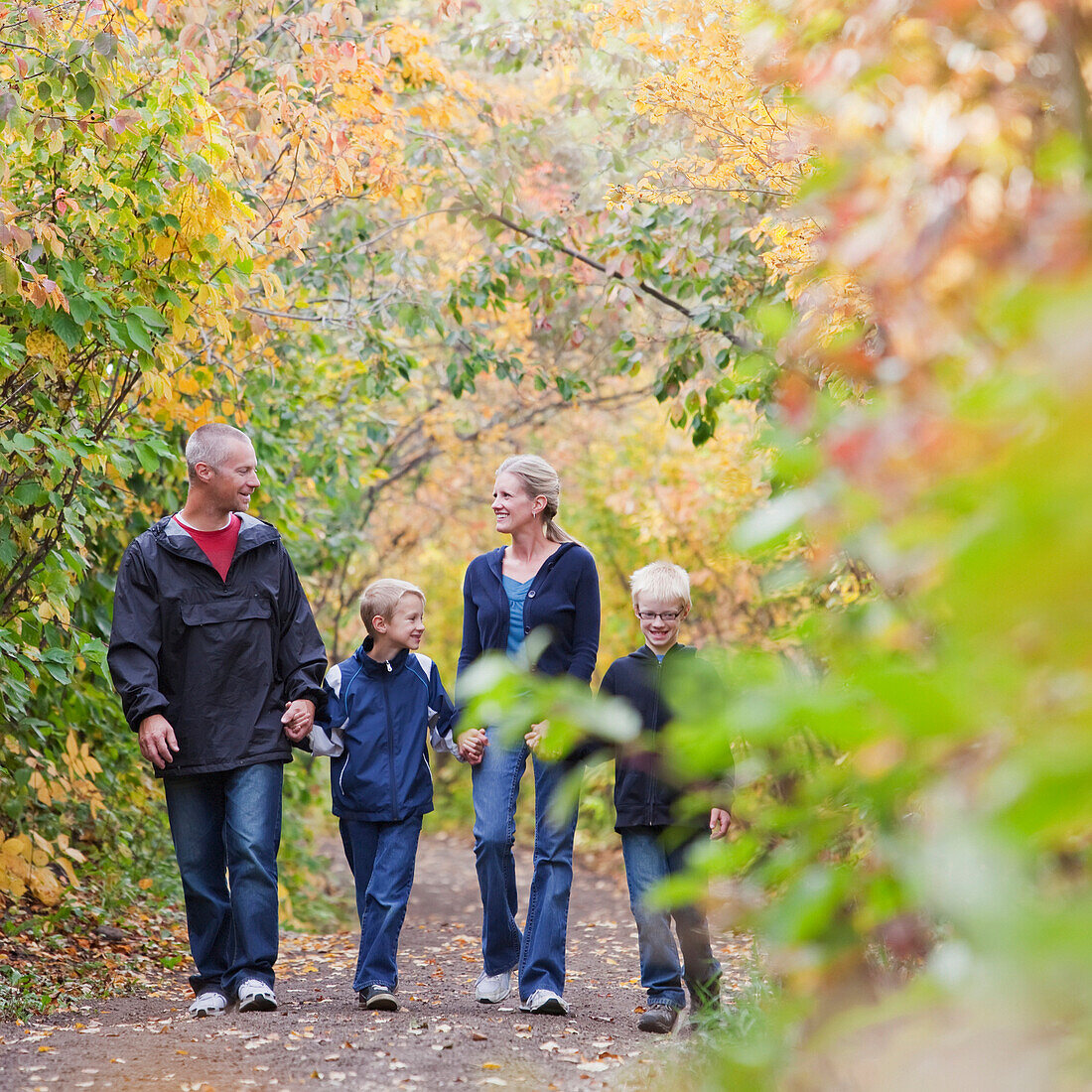 'Family Walking Together On A Path In A Park In Autumn; Edmonton, Alberta, Canada'