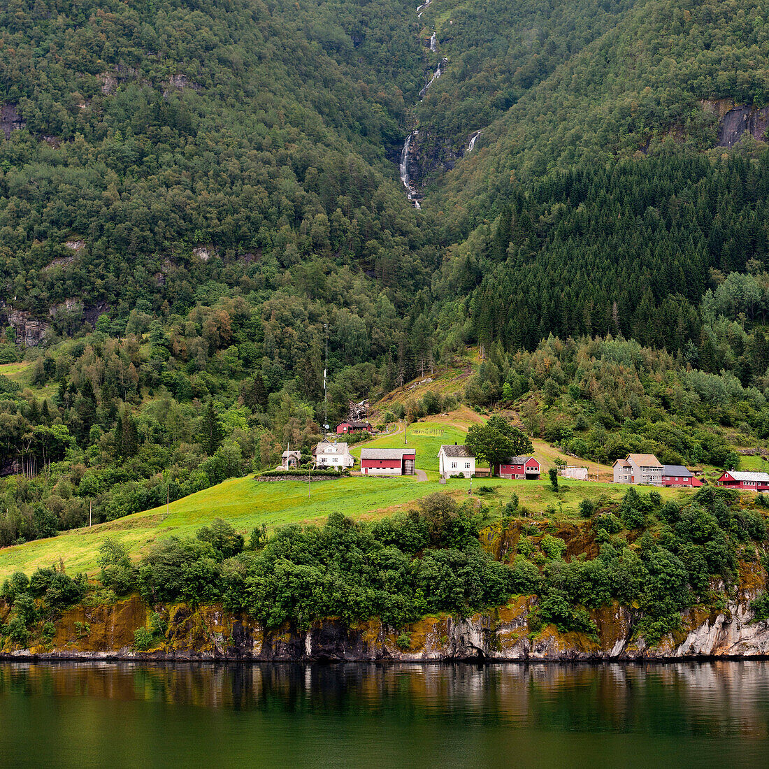 'Houses At The Base Of A Tree Covered Mountain Along The Water's Edge; Granvin, Norway'