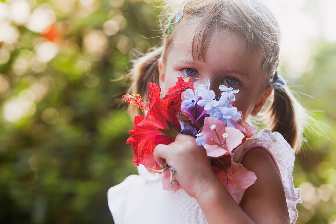 'A young girl smelling a colourful bouquet of flowers;Torremolinos malaga spain'