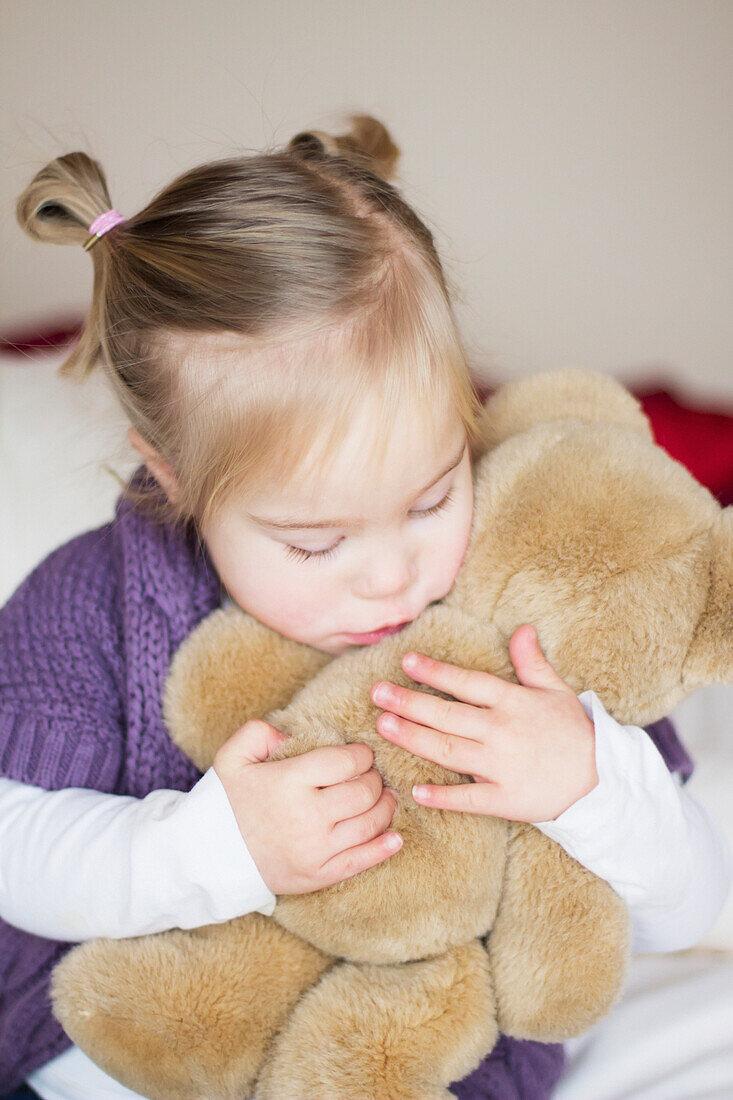 'A Young Girl With Down Syndrome Cuddles With Her Teddy Bear; Cambridge, England'