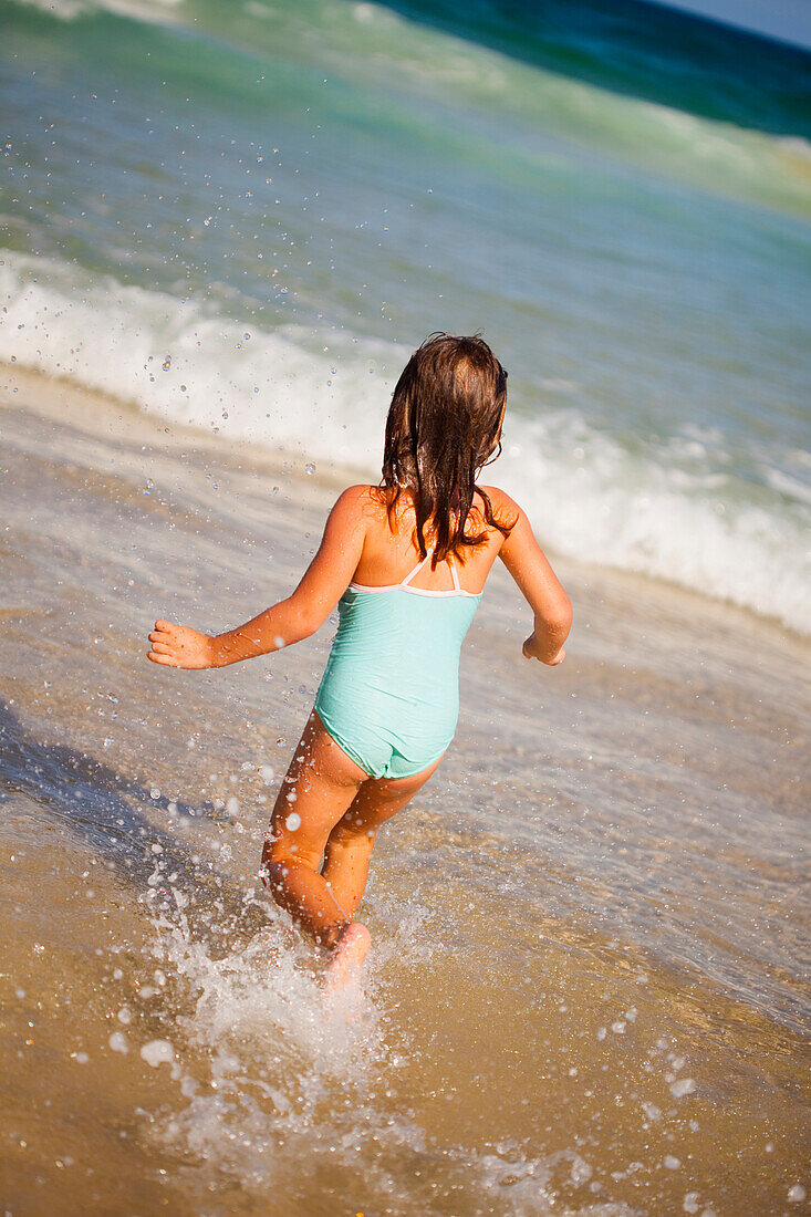 'A young girl runs in the ocean from the beach;Gold coast queensland australia'