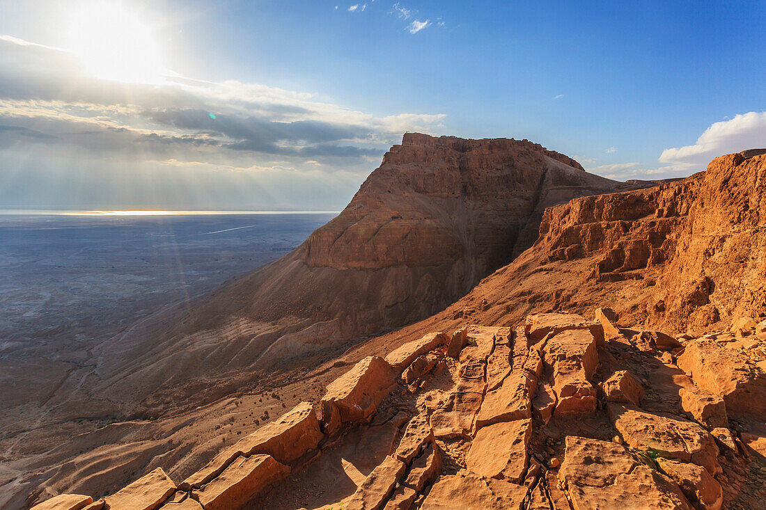 'Rugged terrain and sunbeams at sunrise;Masada israel'