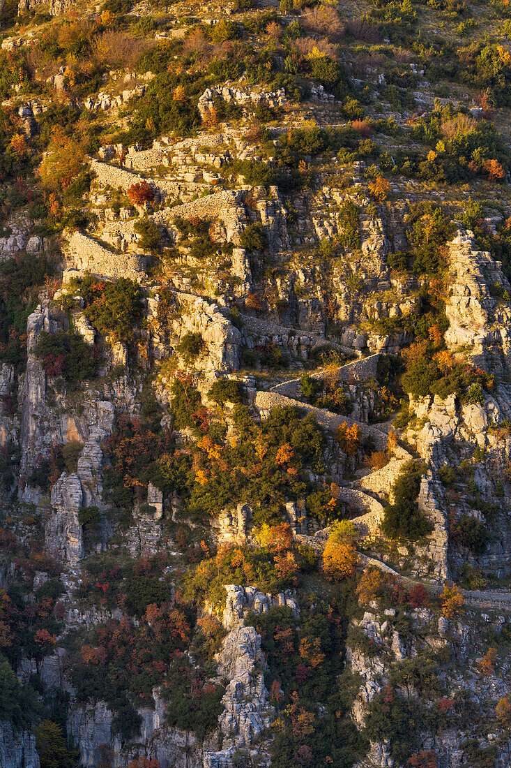 'The last rays of autumn sun highlight the twists and turns of the vradeto steps in zagoria;Epirus greece'