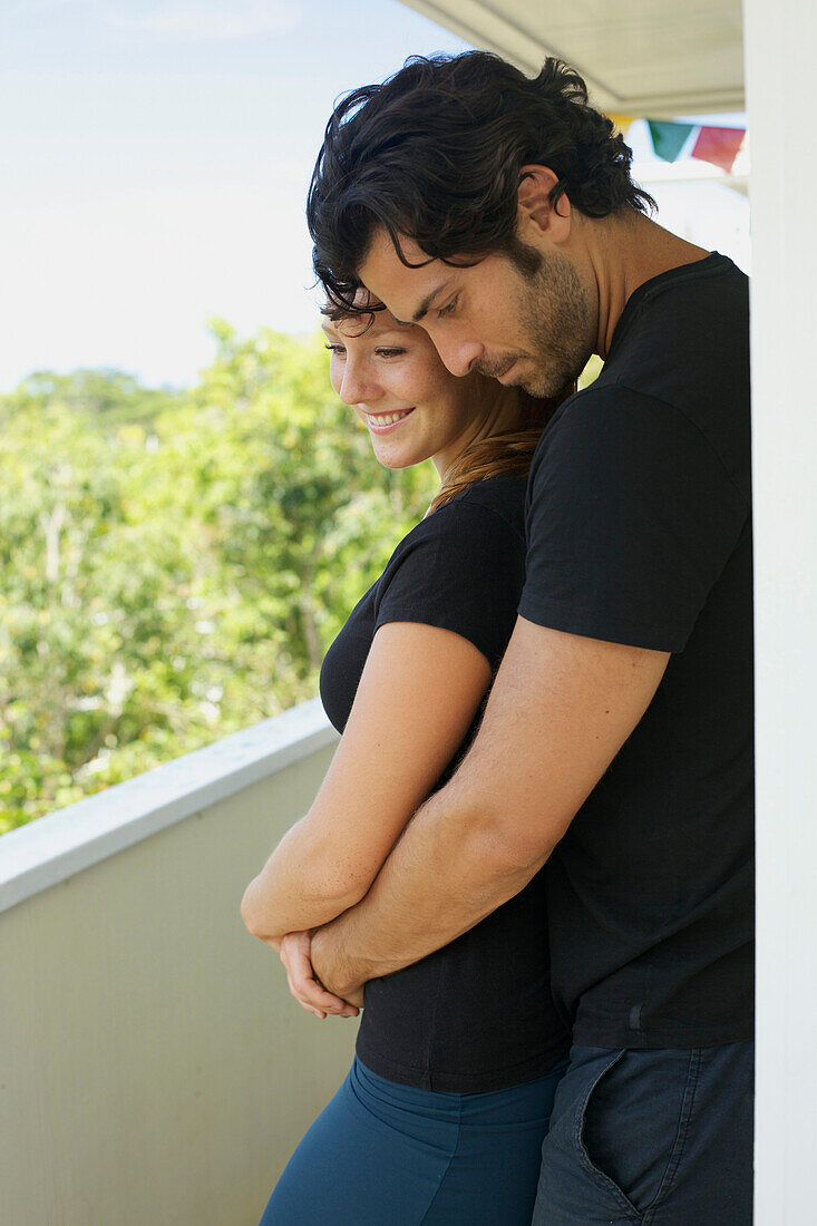 'A man and woman standing close together on a balcony;Wailua kauai hawaii united states of america'