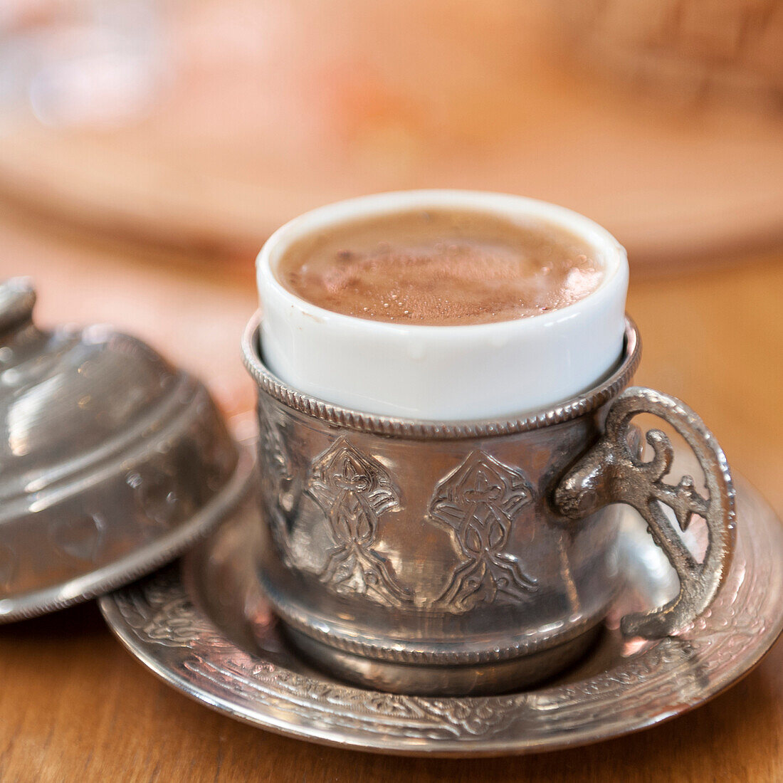 'Hot beverage with foam served in a silver cup and saucer set;Istanbul turkey'