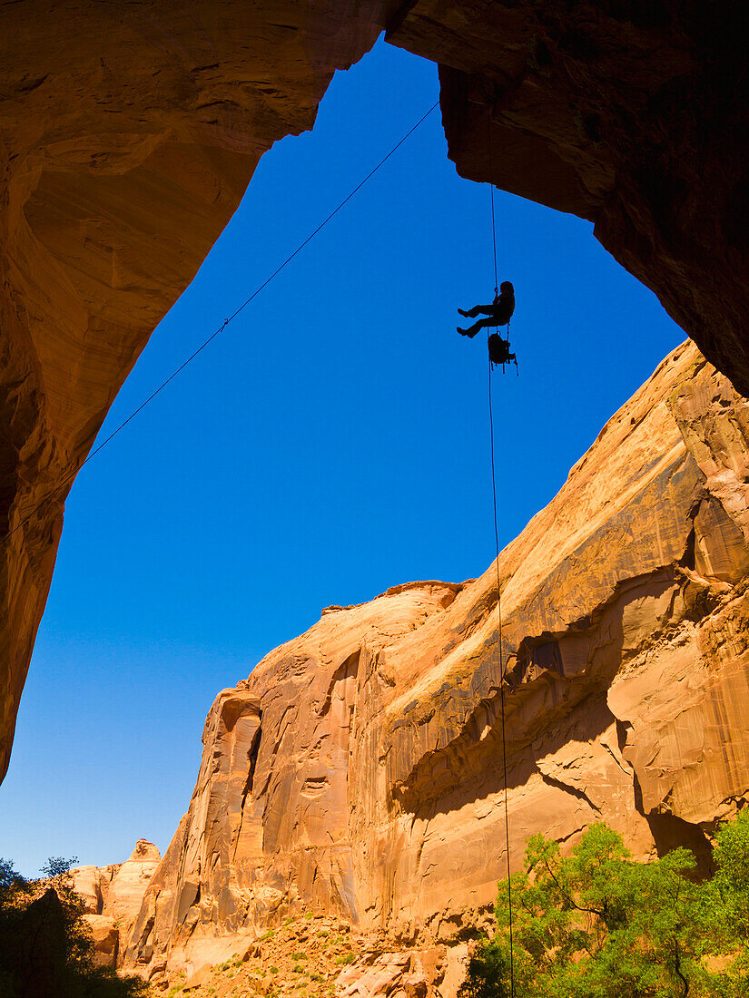 'A female athlete rappeling down a dry utah slot canyon waterfall;Hanksville utah united states of america'