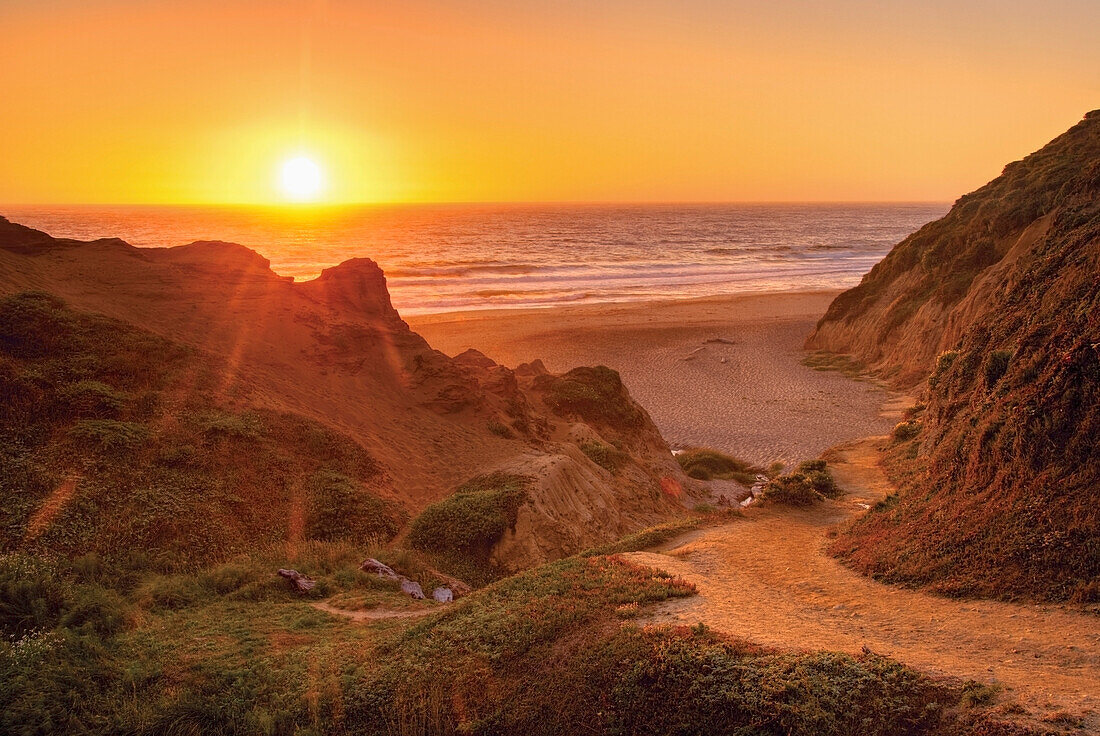 'Orange california sunset on the ocean with trail down to a beach;California united states of america'