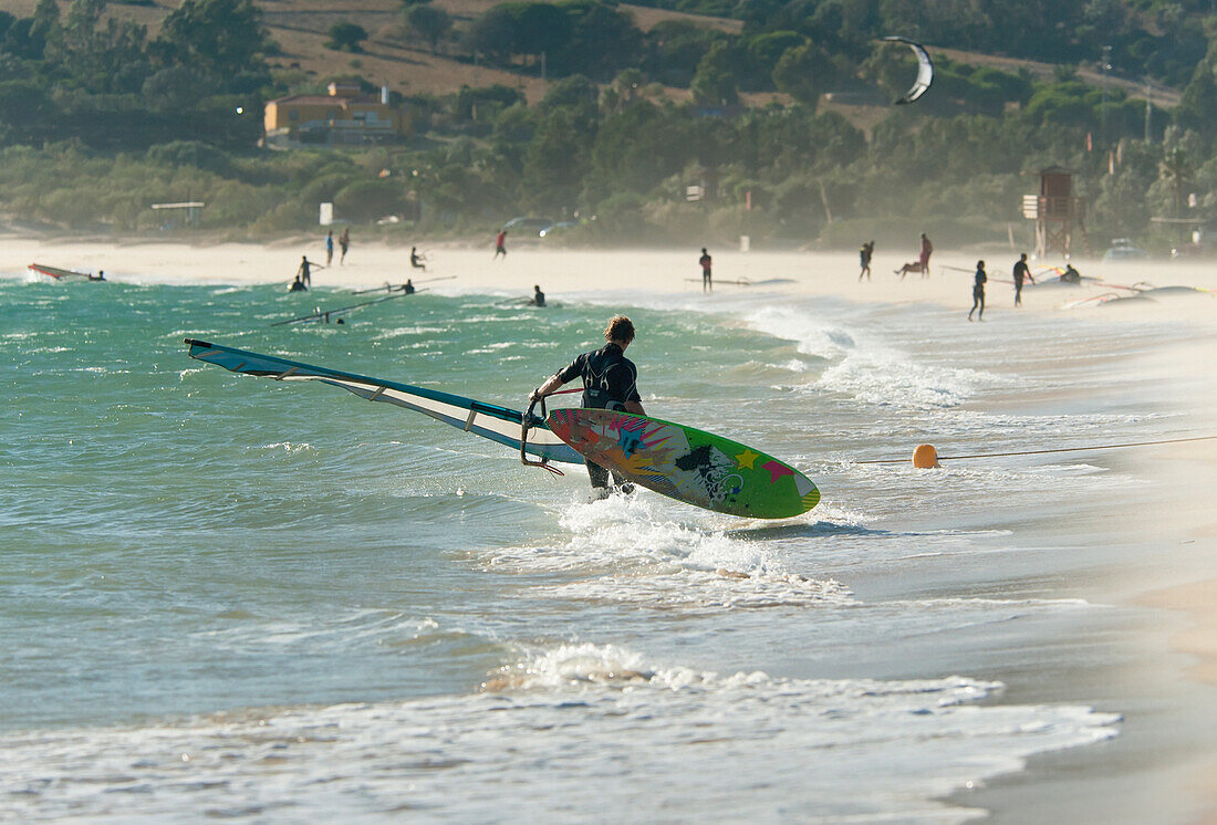 'A Man On The Beach With His Windsurfing Board; Tarifa, Cadiz, Andalusia, Spain'