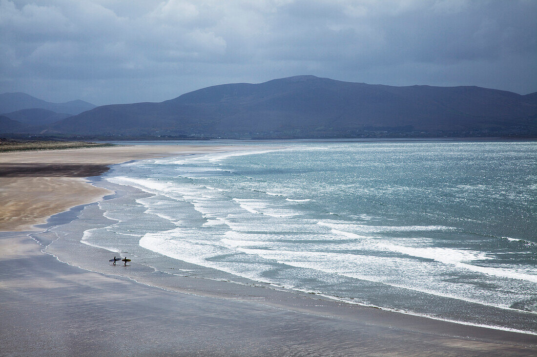 'Two People Walking With Surfboards On The Beach In Inch On The Dingle Peninsula; County Kerry, Ireland'