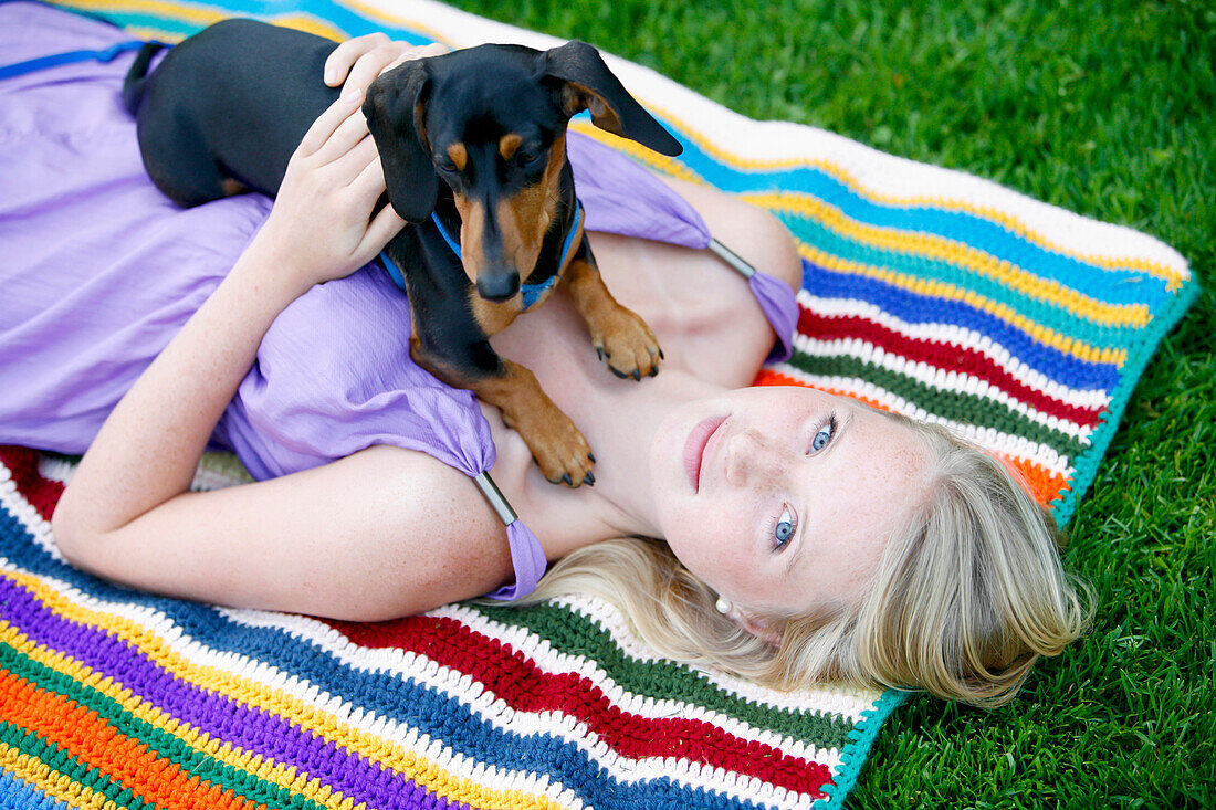 'Woman Relaxing With Her Miniature Dachshund; Victoria, Vancouver Island, British Columbia, Canada'