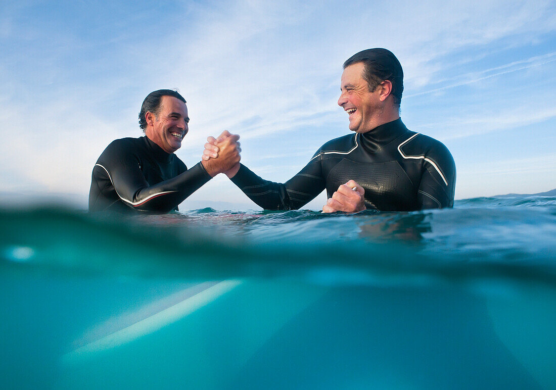 'Male Wakeboarders In The Ocean Shaking Hands; Tarifa, Cadiz, Spain'