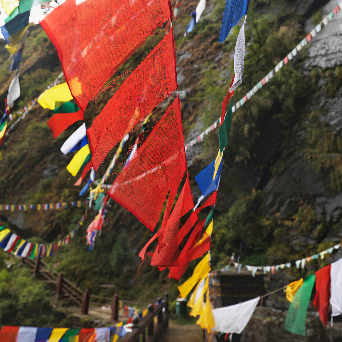 'Prayer Flags Hanging Over A Wooden Walkway At Tiger's Nest Monastery; Paro Valley, Taktsang, Bhutan'