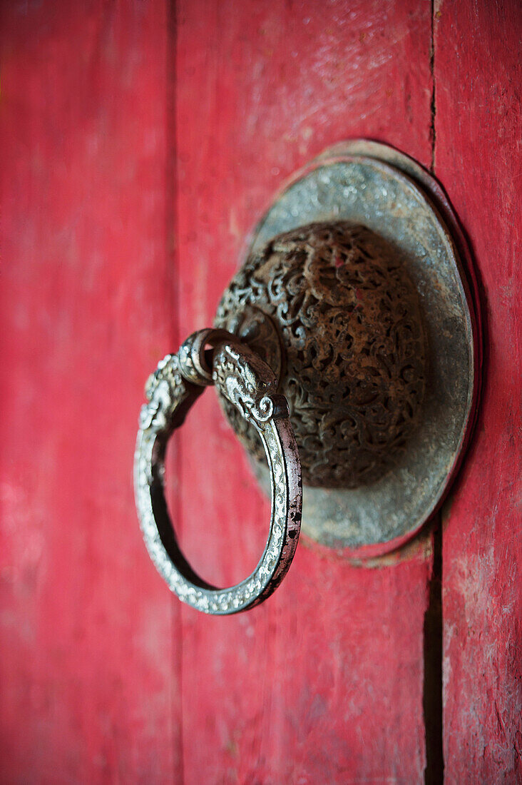 'Ornate Door Handle On A Red Wooden Door; Bhutan'