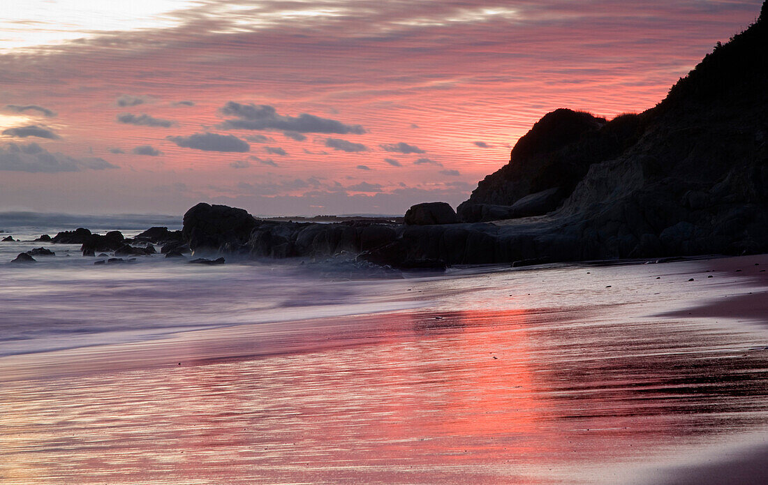 Sunset Over Water At A Rocky Shoreline