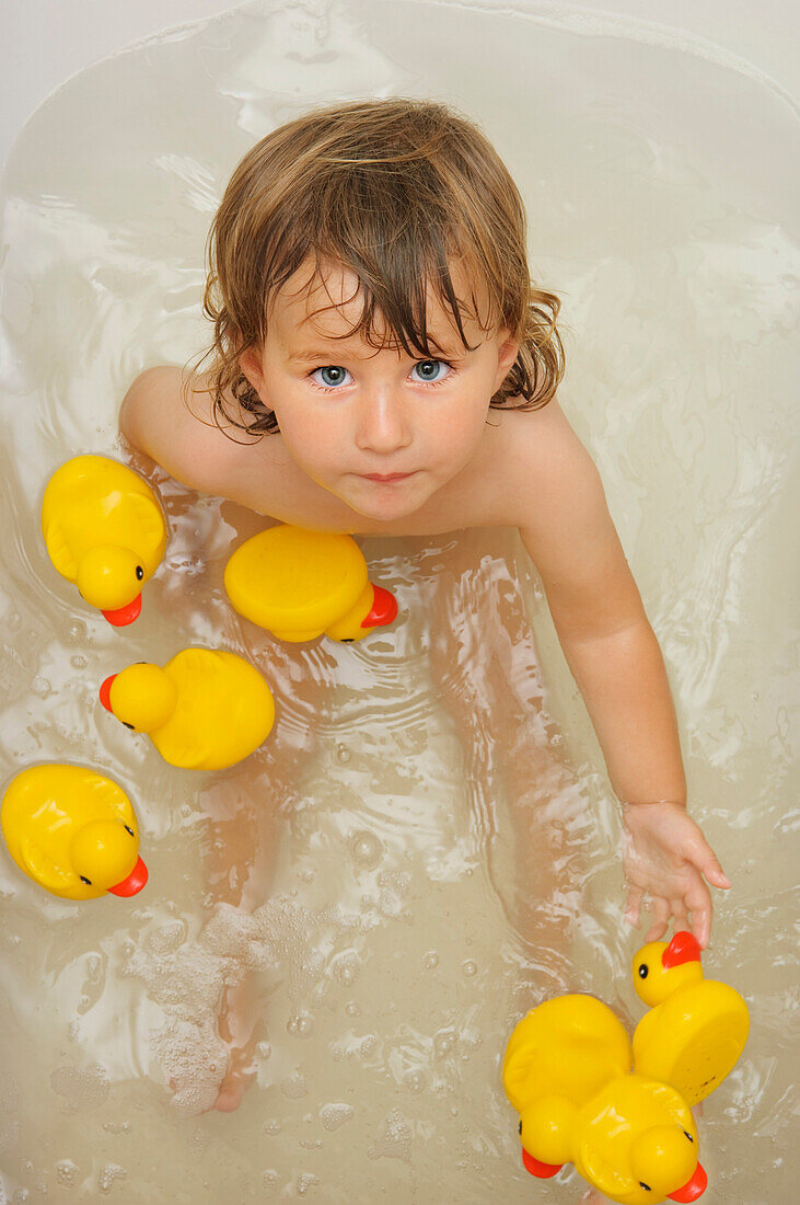 Mädchen in der Badewanne mit Gummi-Enten