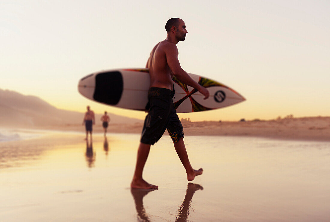 'A Man Walking With His Surfboard On Valdevaqueros Beach; Tarifa Cadiz Andalusia Spain'