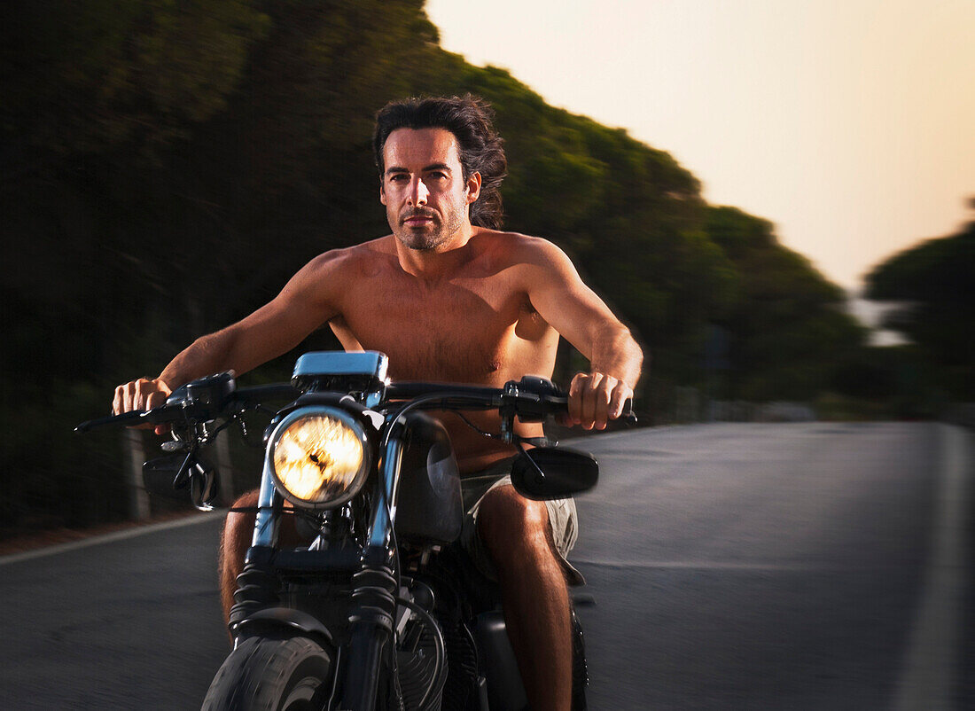 'Shirtless Man Riding A Motorcycle; Tarifa, Cadiz, Andalusia, Spain'
