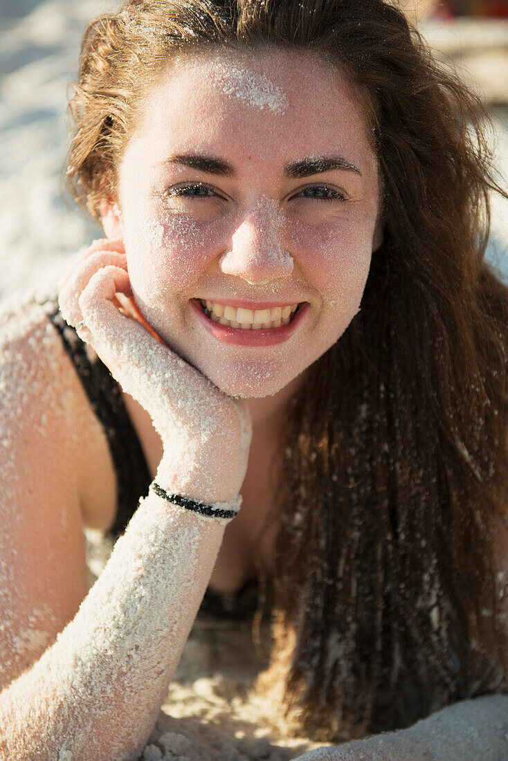 'Girl at the beach covered in sand; Koh Samet Island, Thailand'