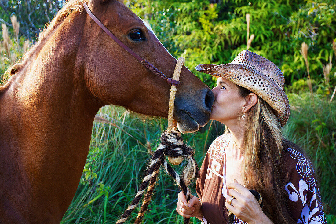 'A woman kiss the nose of a horse; Hawaii, United States of America'