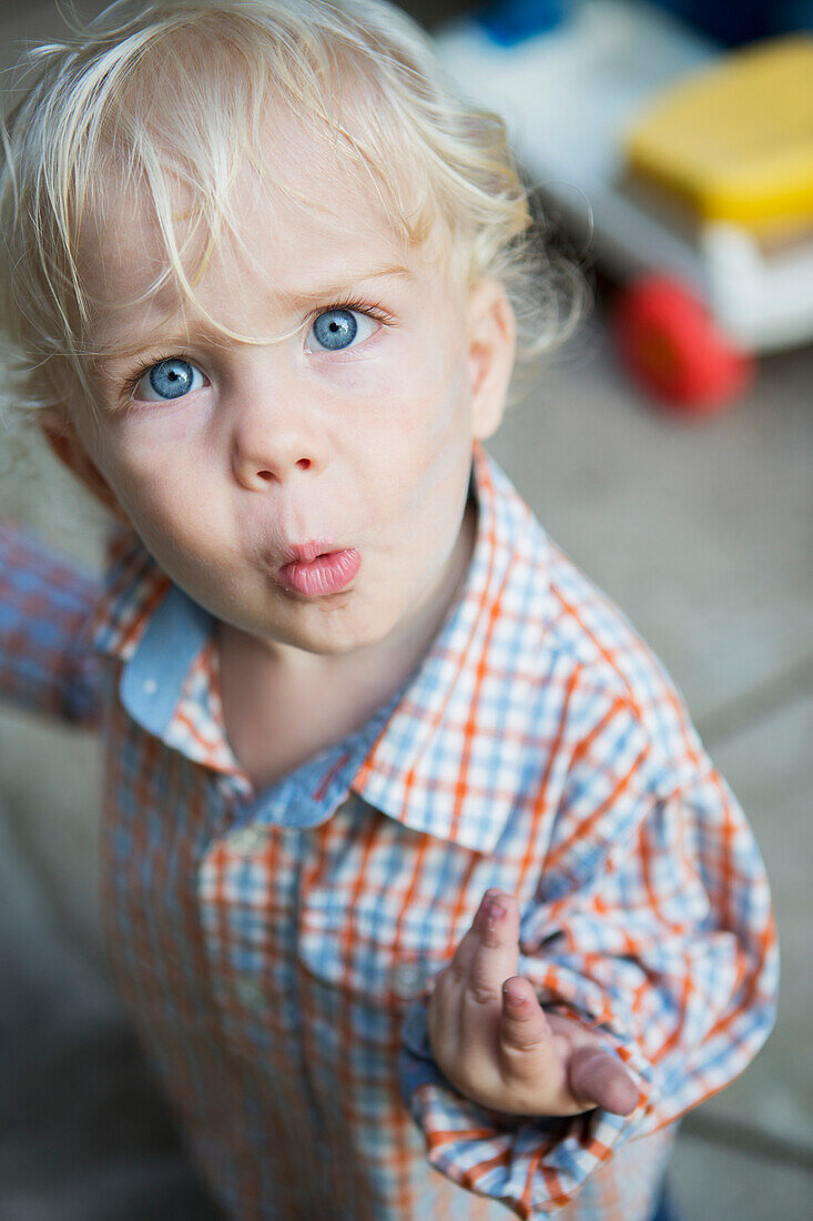 'Young boy looks quizzically up at the camera; Toronto, Ontario, Canada'