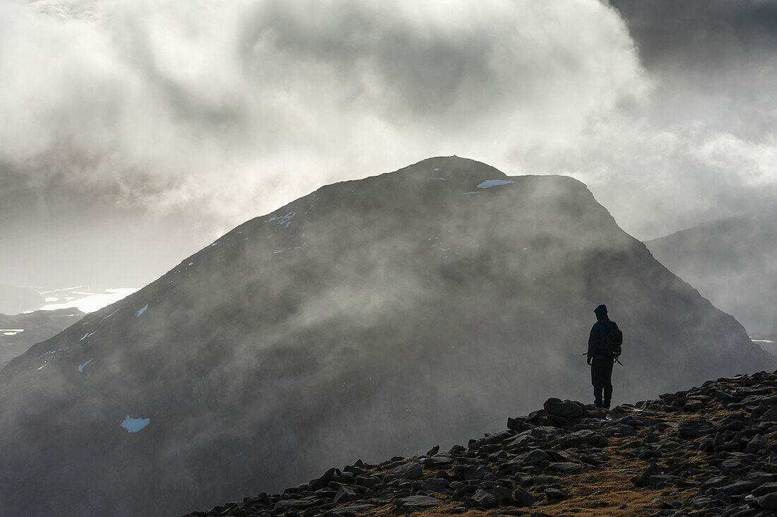 'A man stands looking out from the summit of Maol Chean-dearg; Torridon, Scotland'