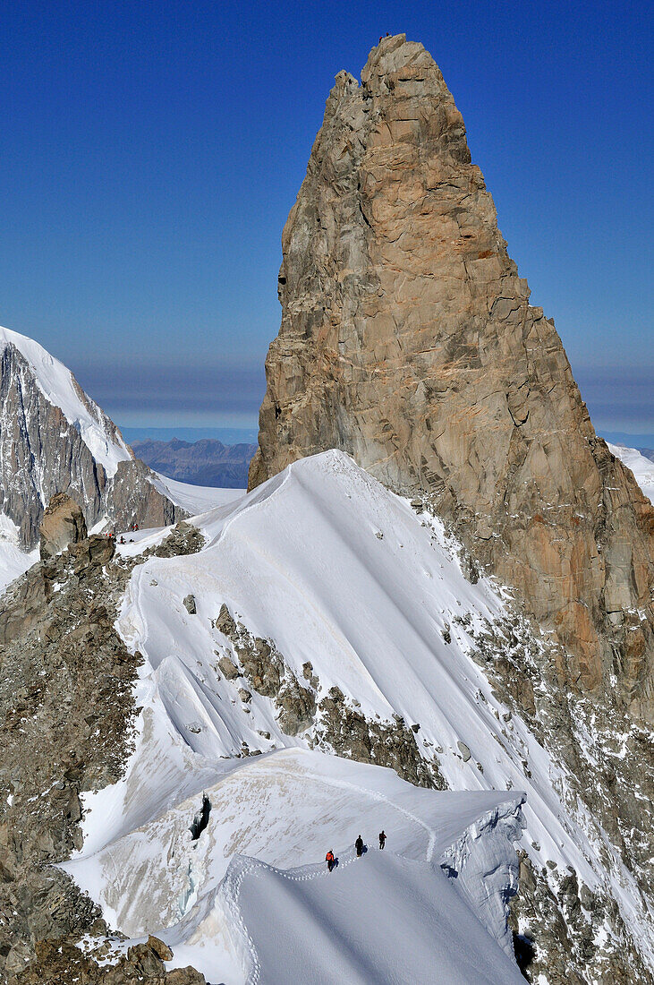 Bergsteiger auf einer Wechte am Rochefortgrat, Dent du Geant im Hintergrund, Mont Blanc-Gruppe, Frankreich