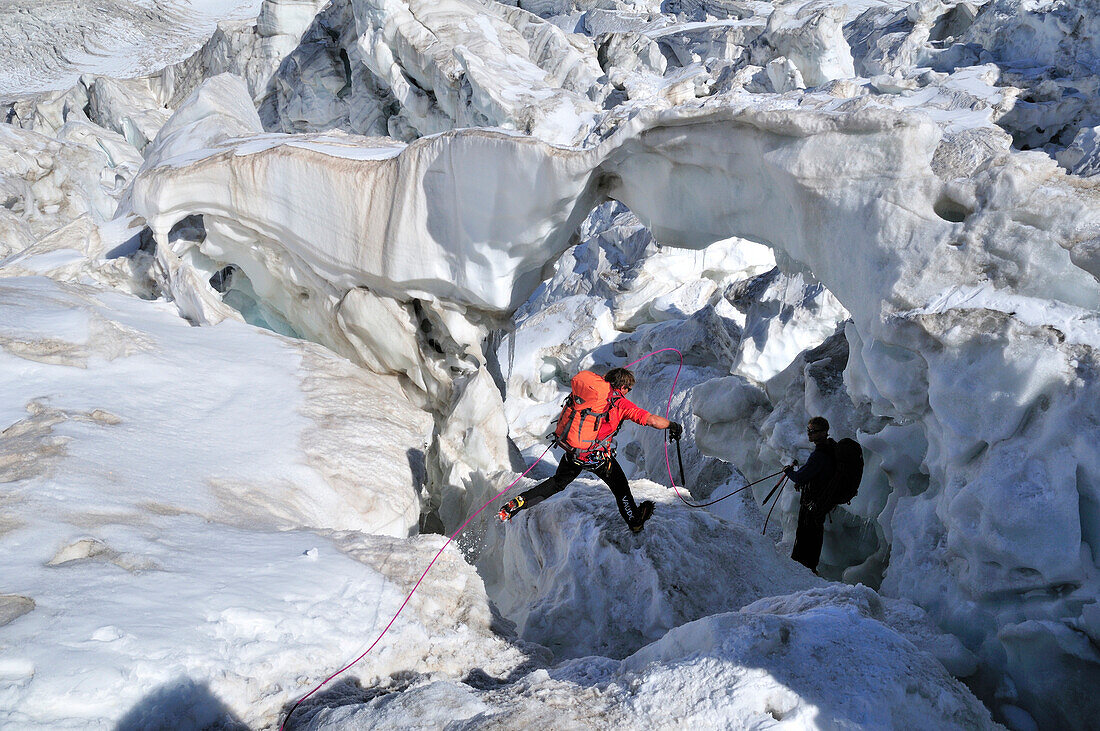 Bergsteiger springen über eine Gletscherspalte, Vallee Blanche, Mont Blanc-Gruppe, Frankreich
