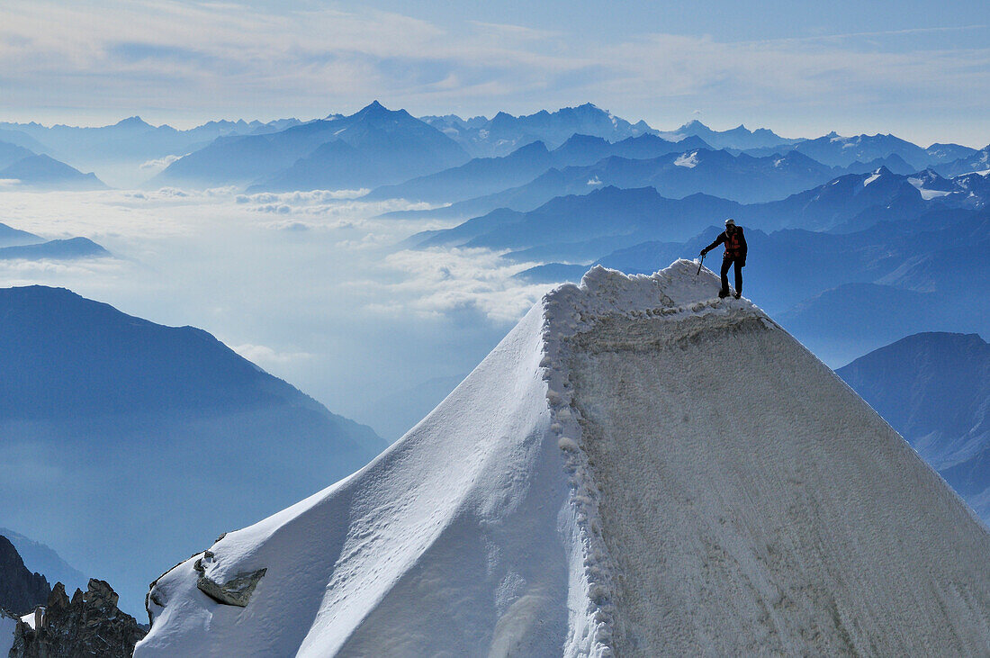 Bergsteiger auf einer Wechte am Kuffnergrat des Mont Maudit, Aostatal im Hintergrund, Mont Blanc-Gruppe, Frankreich