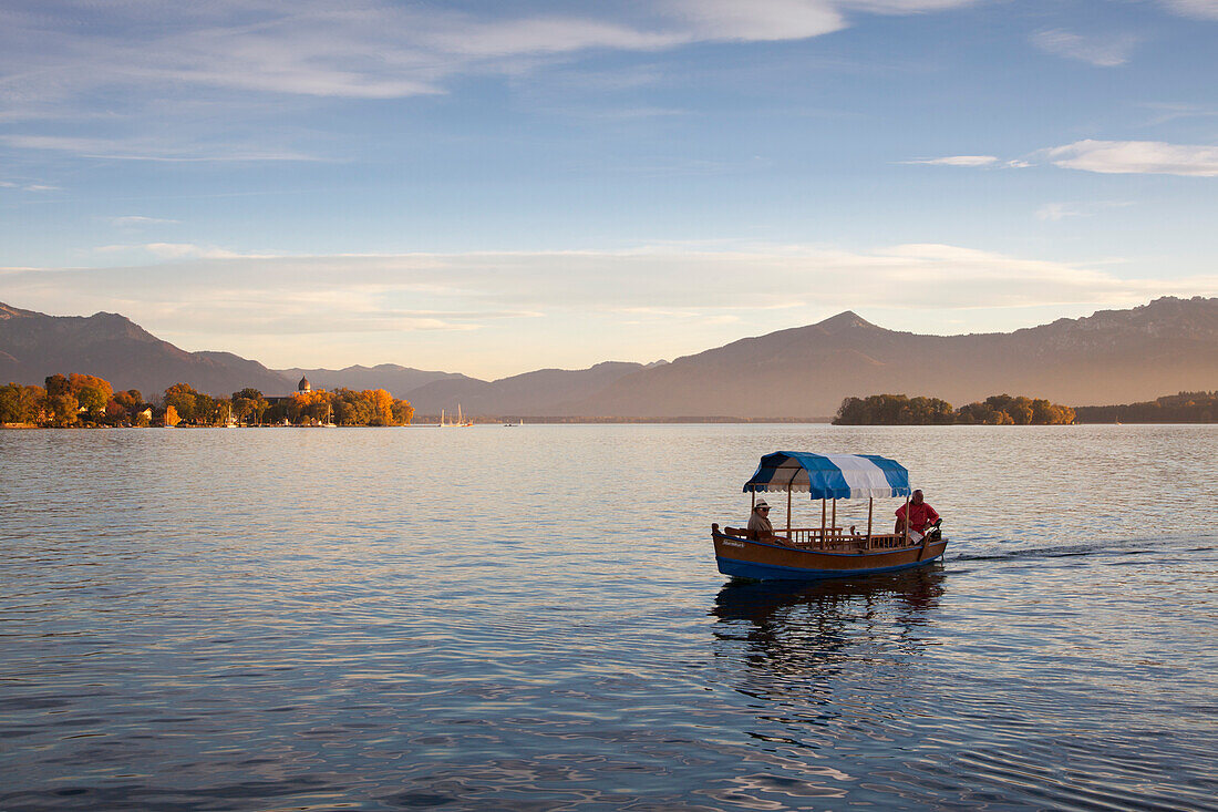 Paar in einem Boot, Blick über den Chiemsee zur Fraueninsel, bei Gstadt, Chiemsee, Chiemgau, Bayern, Deutschland