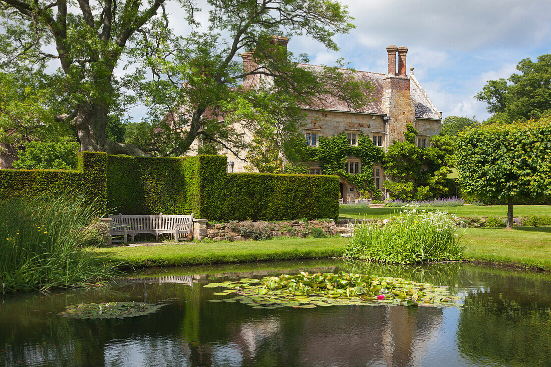 Blick über den Seerosenteich zum Herrenhaus, Bateman's, Haus des Schriftstellers Rudyard Kipling, East Sussex, Großbritannien