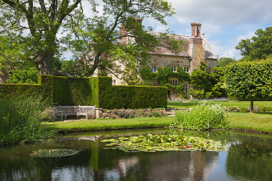View across the lily pond to the manor house, Bateman's, home of the writer Rudyard Kipling, East Sussex, Great Britain