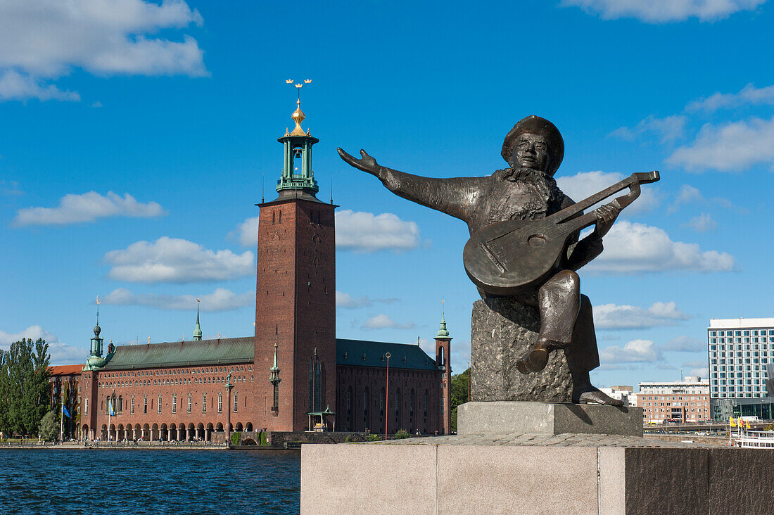 Denkmal von Komponist Evert Taube, Stadshuset im Hintergrund, Stockholm, Schweden