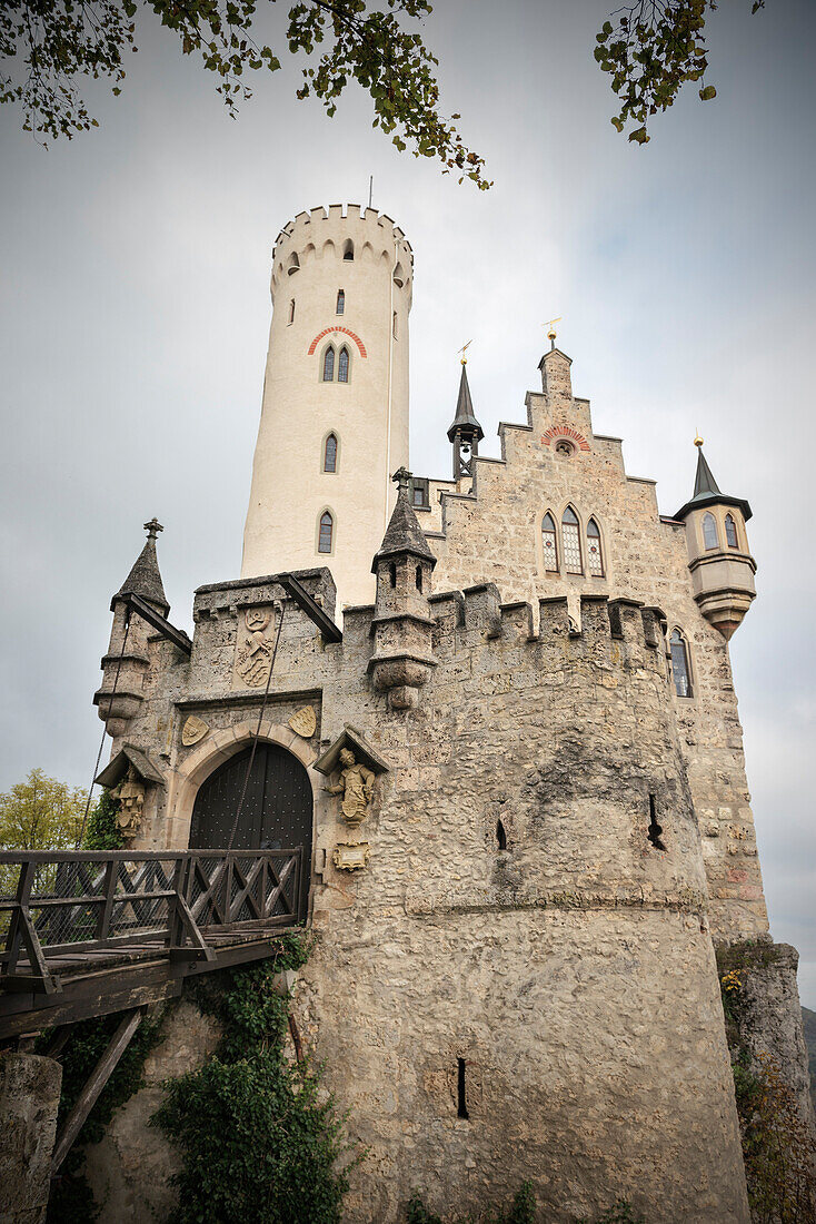 Blick auf Schloss Lichtenstein mit Zugbrücke im Herbst, Schwäbische Alb, Baden-Württemberg, Deutschland