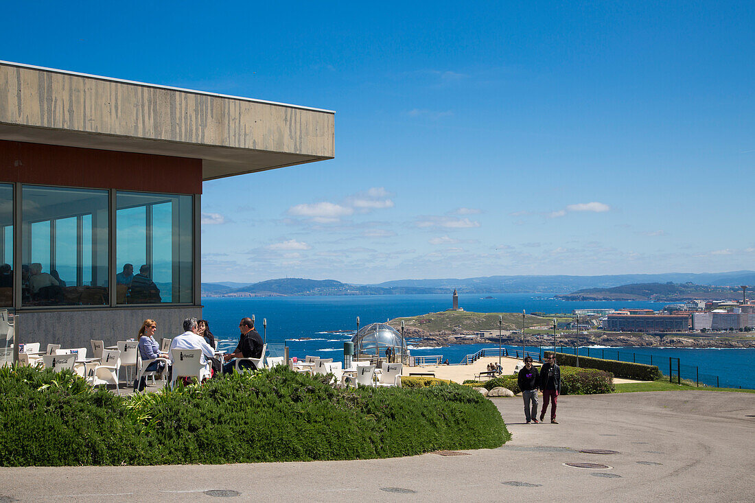Menschen vor Restaurant am San Pedro Hügel mit Blick auf Küste und Herkulesturm, LA Coruna, Galicien, Spanien, Europa