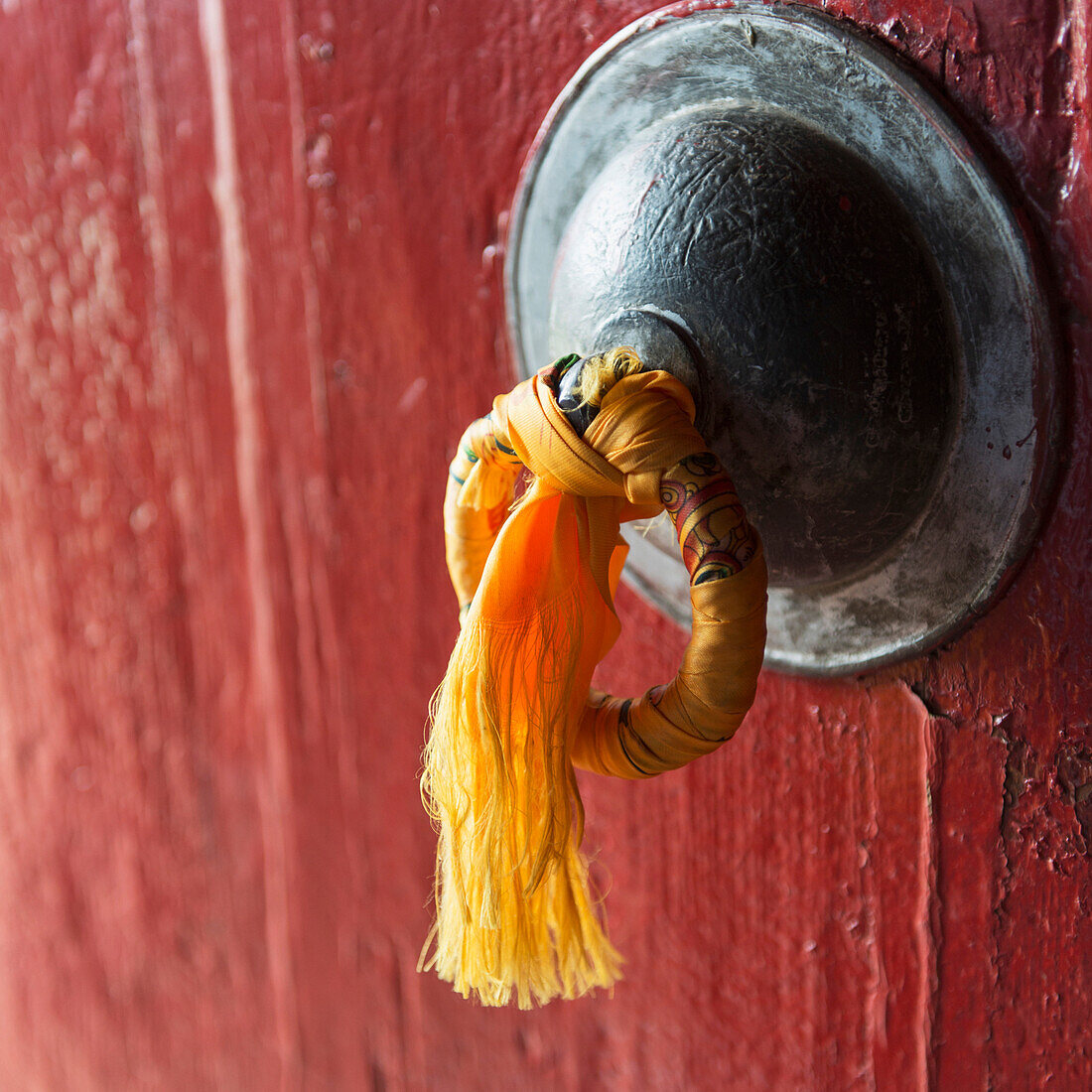 'Gold tassel tied to a doorknob on a red door;Lhasa xizang china'