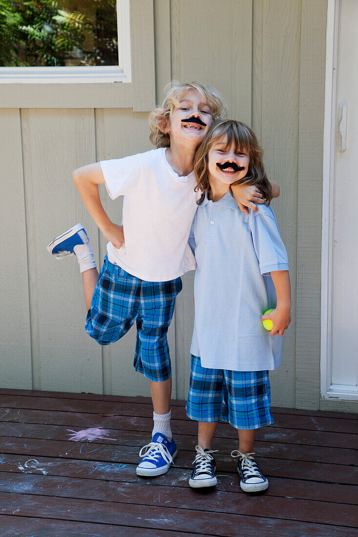 'Brothers posing with pretend moustaches;Pacifica california united states of america'