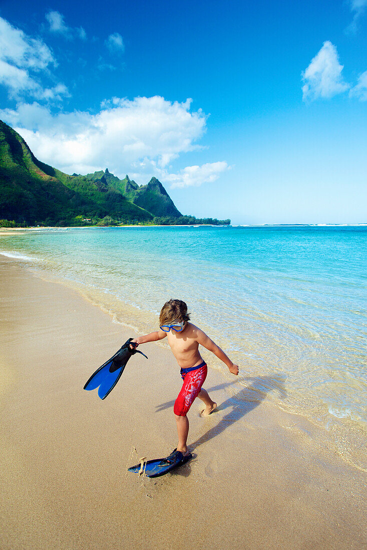 'A boy on the beach with snorkelling gear; Kauai, Hawaii, United States of America'