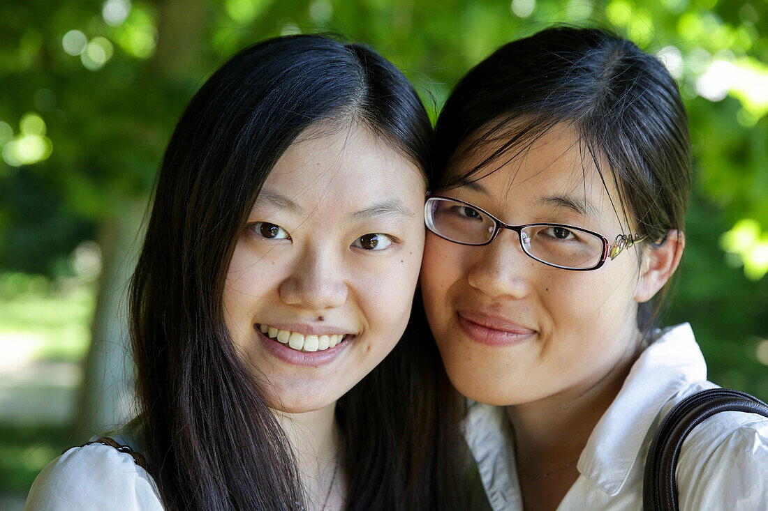 Two young women smiling at camera, Leipzig, Saxony, Germany