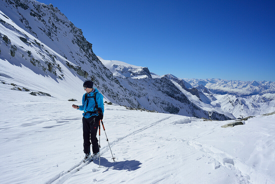 Female back-country skier controlling GPS-device, Griererkar, Realspitze, Zwerchwand, Zillertal, Zillertal Alps, Tyrol, Austria