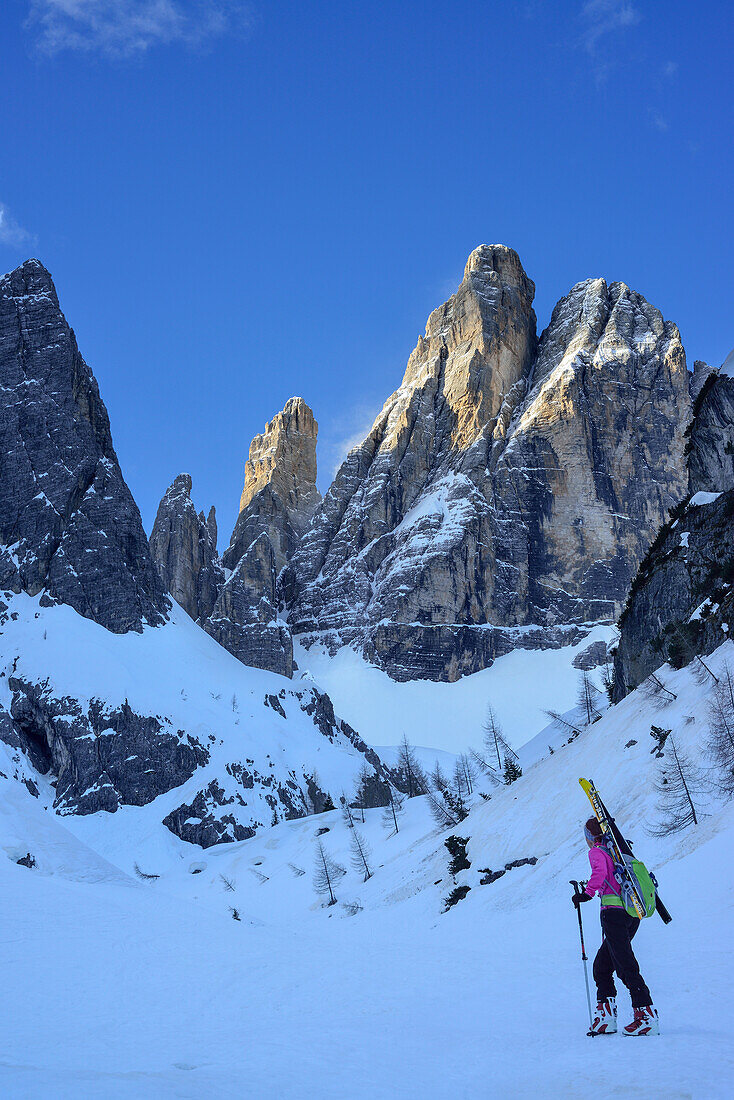 Frau auf Skitour steigt zur Hochbrunnerschneid auf, Hohe Leist und Zwölferkogel im Hintergrund, Hochbrunnerschneid, Fischleintal, Sextener Dolomiten, Südtirol, Italien