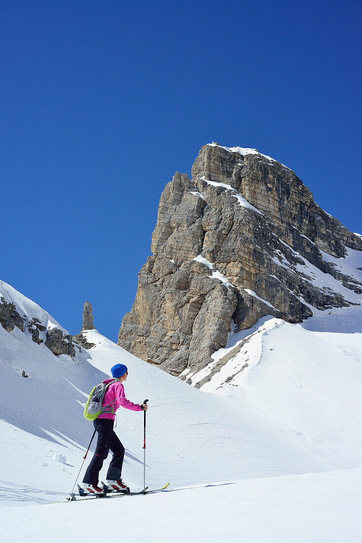 Female back-country skier ascending to Corno d Angolo, Cristallo Group, Dolomites, Veneto, Italy