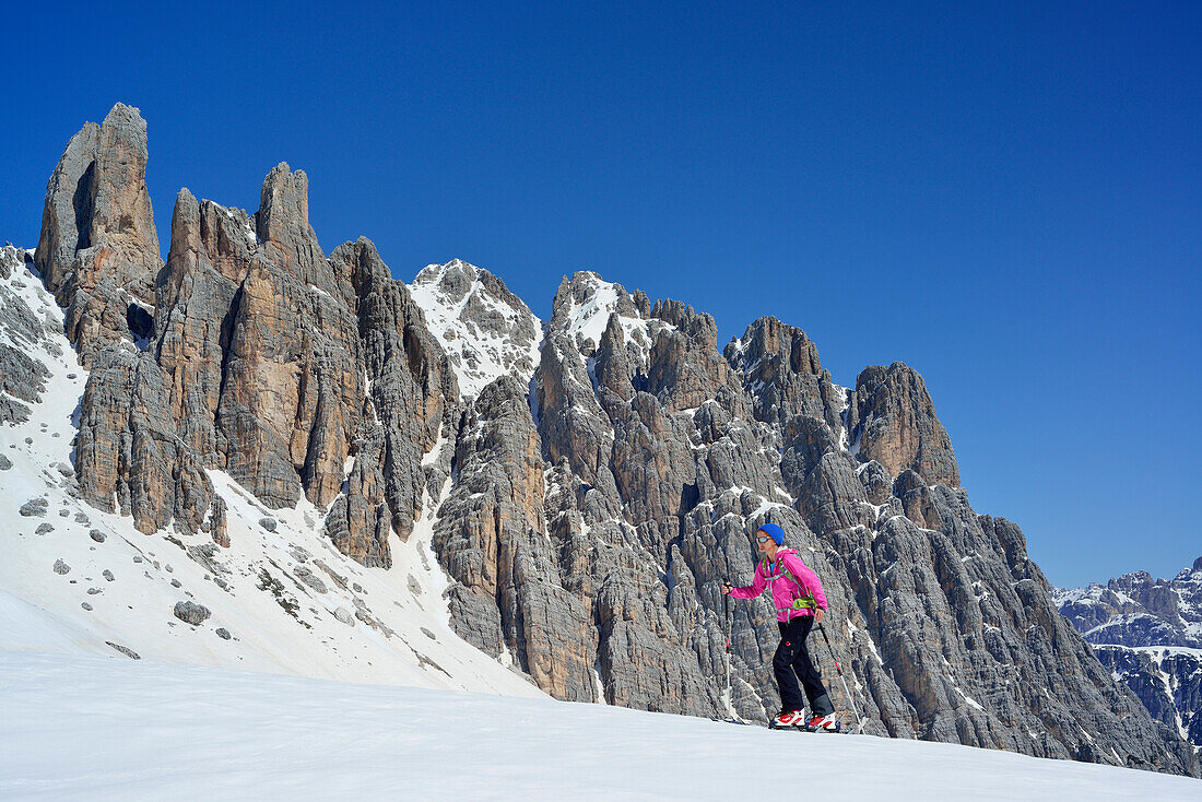 Female back-country skier ascending to Corno d Angolo, Cristallo Group, Dolomites, Veneto, Italy